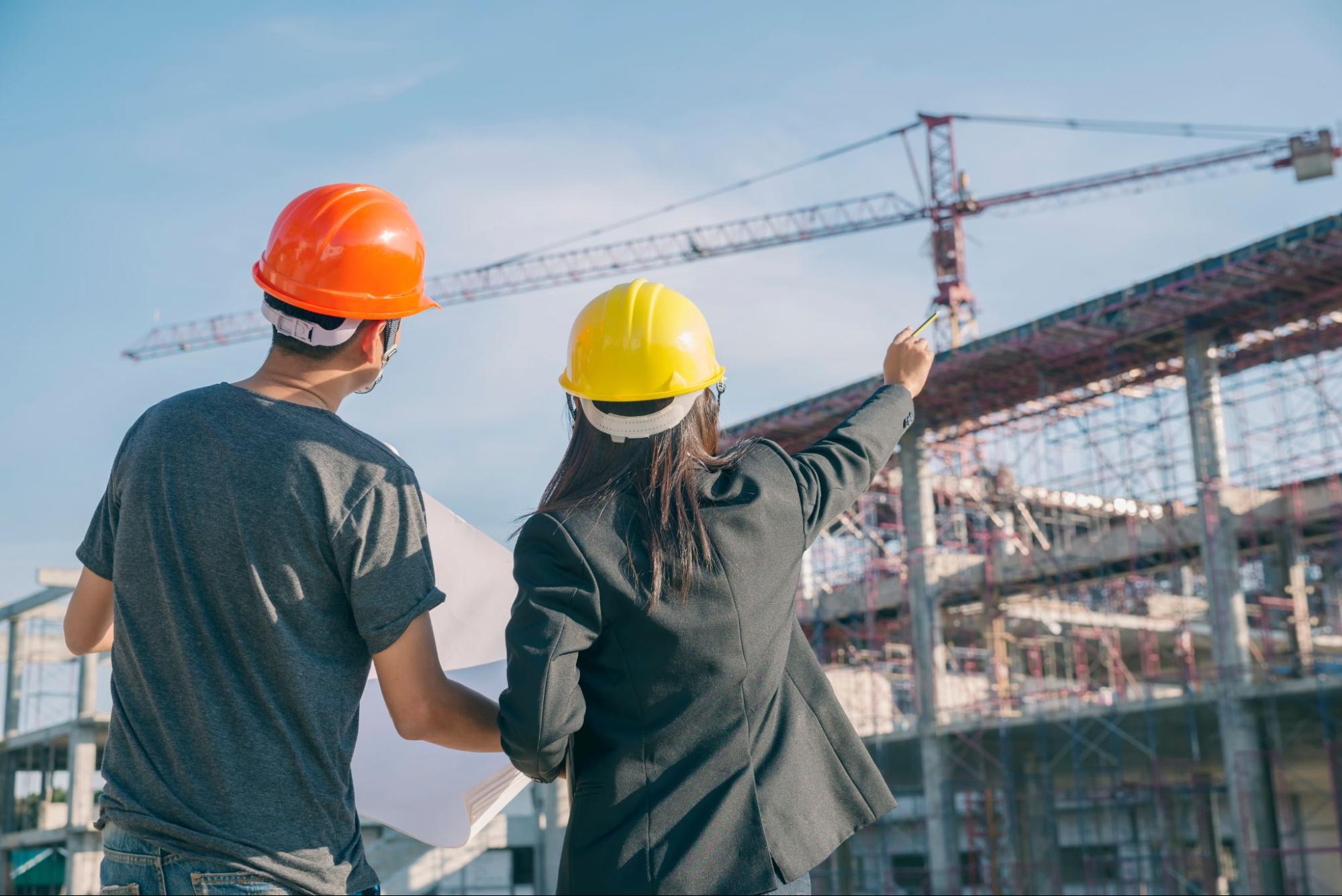 Uma mulher dando instruções em uma obra de construção civil.