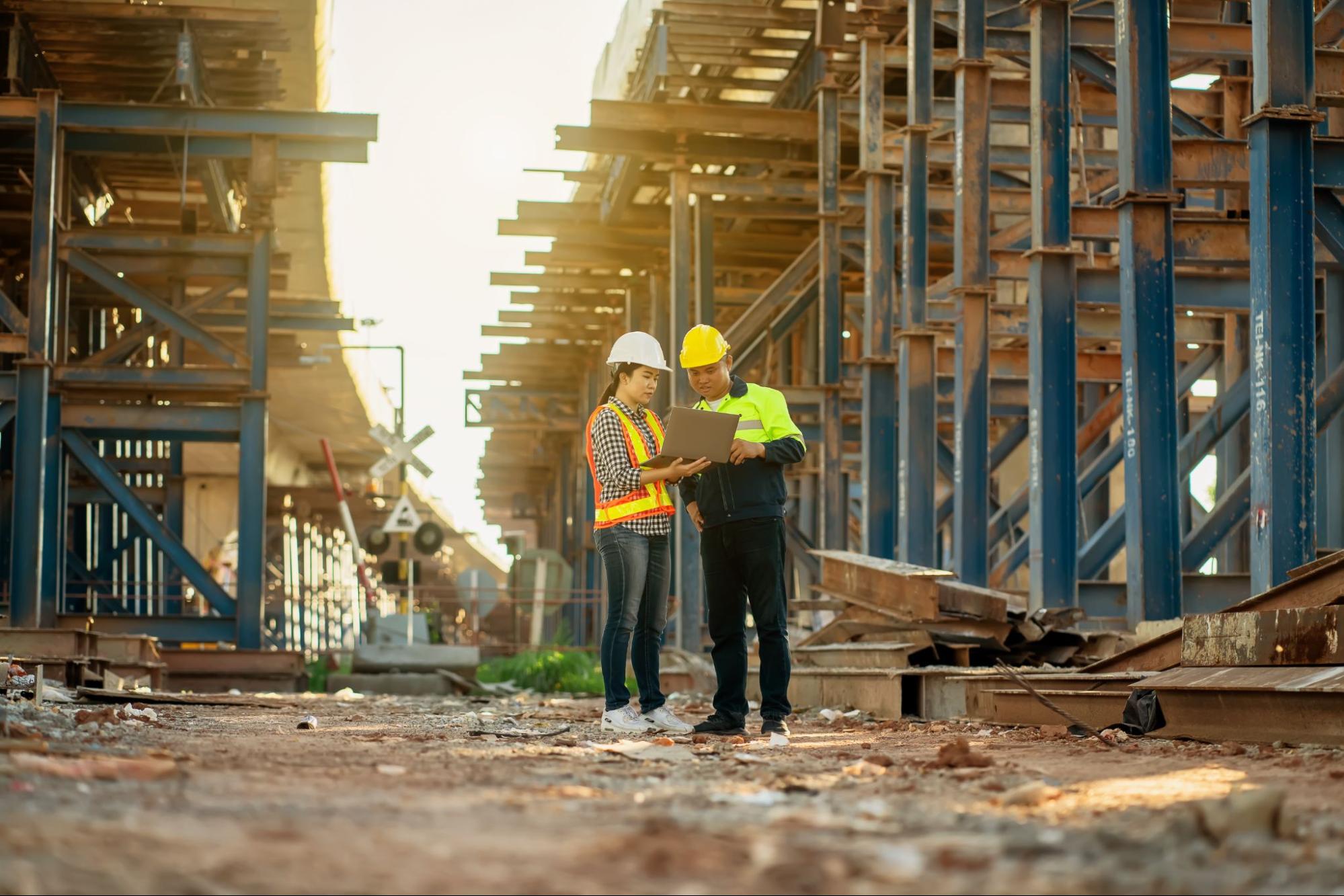 Uma mulher e um homem em um canteiro de obras.